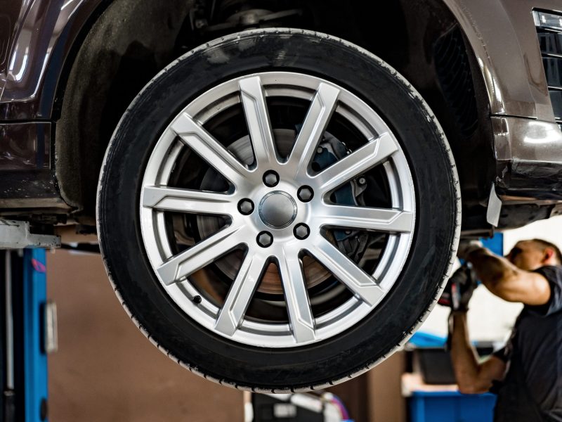 Mechanic repairing under car at the car service garage close up
